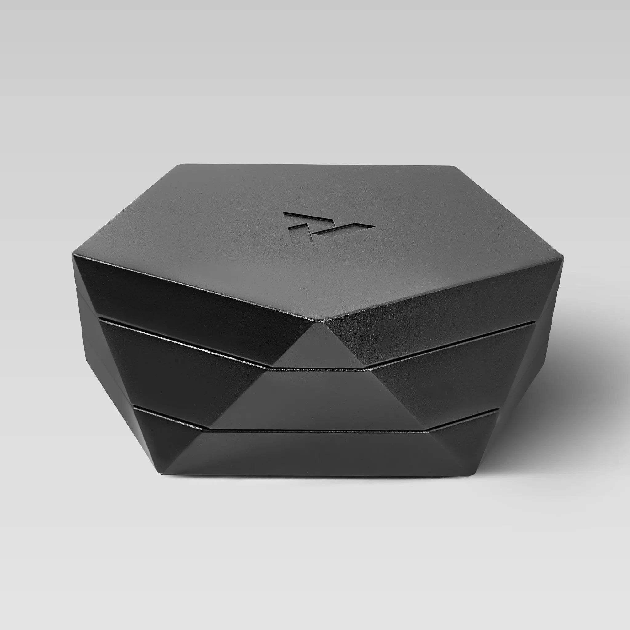 Vesta black magnetic vessel closed, faceted hexagonal form on a light studio background