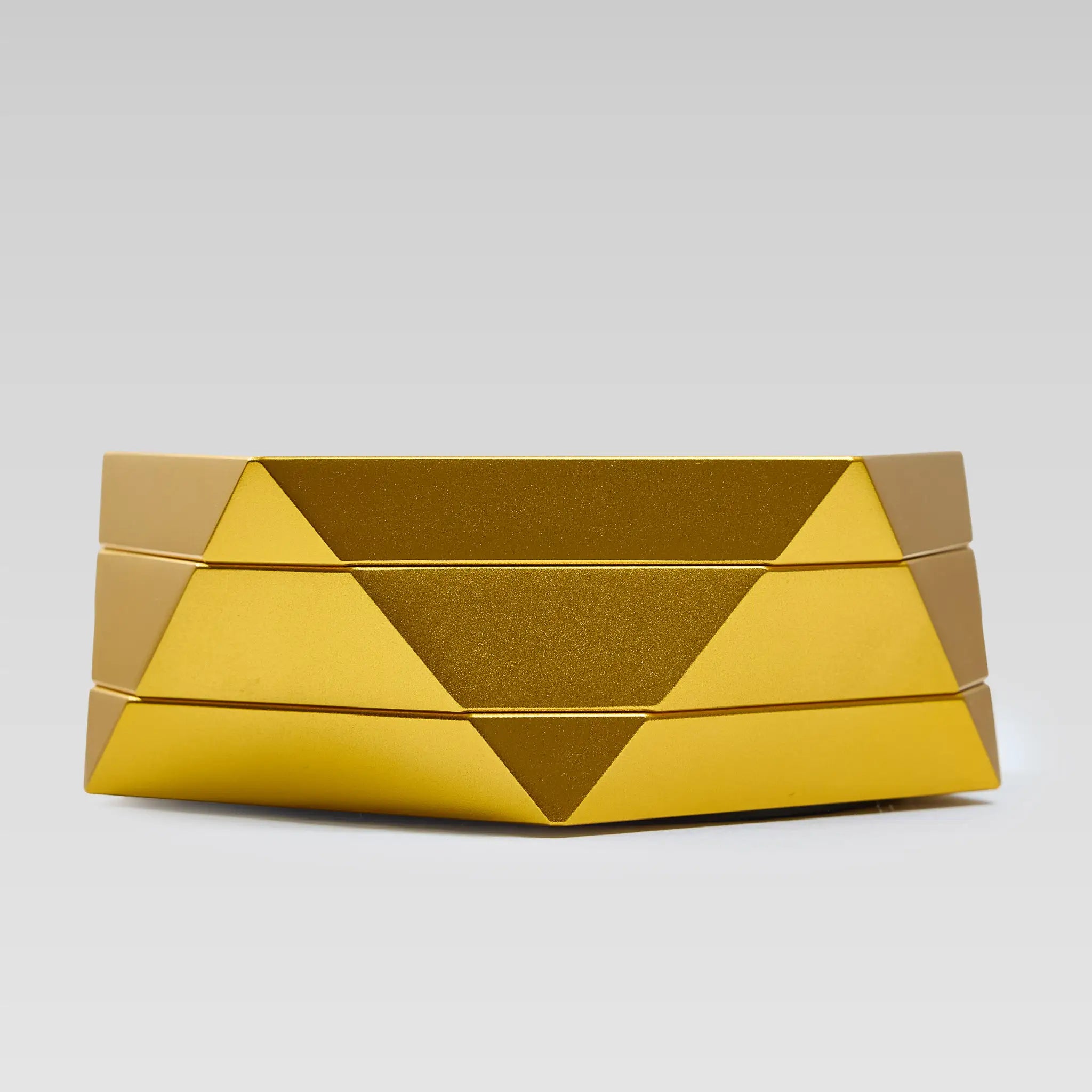 Vesta gold magnetic vessel open, low angle showing the faceted geometric body