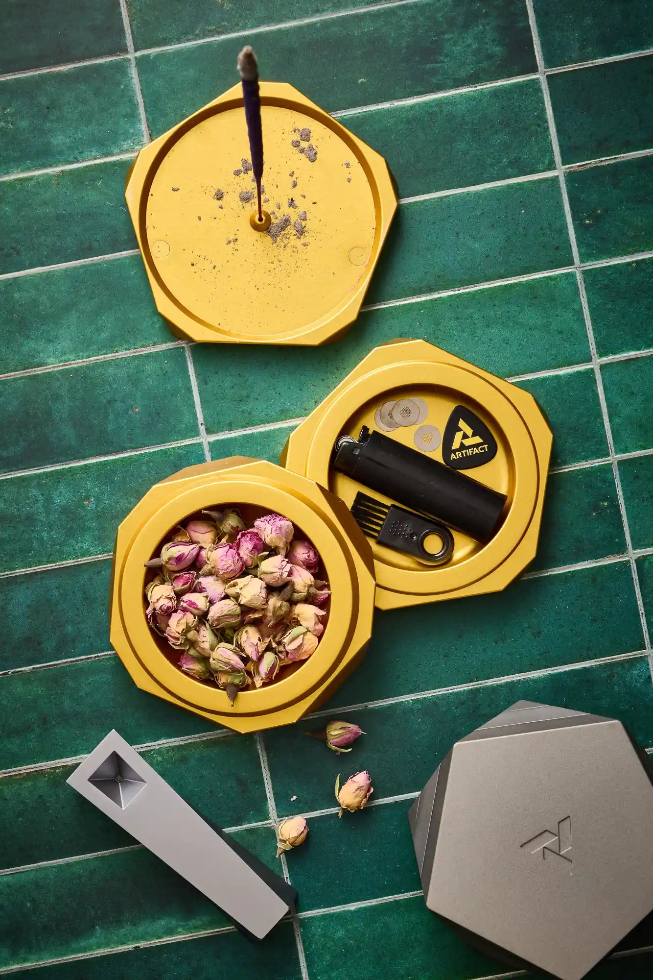 Yellow hexagonal containers with various items on a green tiled surface